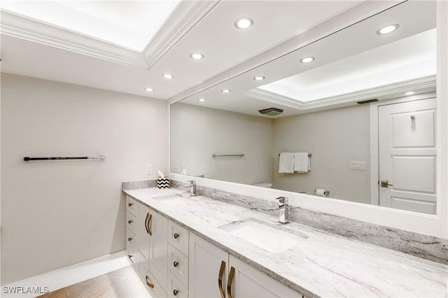 bathroom featuring tile patterned flooring, vanity, a tray ceiling, and crown molding