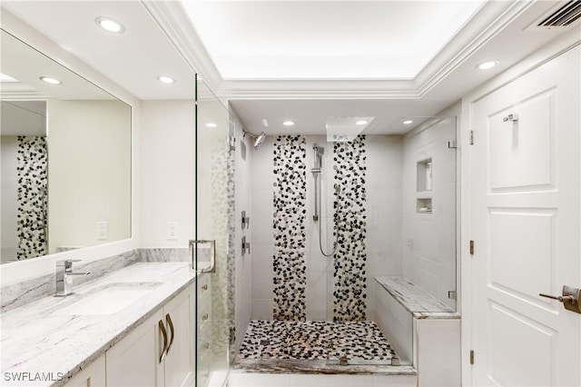 bathroom featuring crown molding, vanity, and a shower with shower door