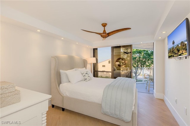 bedroom featuring light wood-type flooring, access to outside, a wall of windows, and ceiling fan