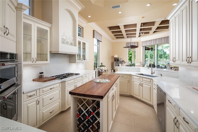 kitchen featuring stainless steel appliances, sink, ornamental molding, butcher block countertops, and coffered ceiling