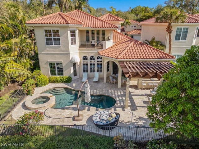 rear view of house featuring a balcony, a patio area, and a pool with hot tub