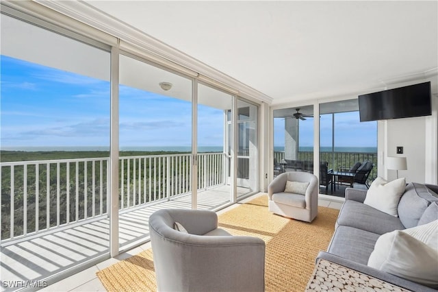 sunroom / solarium with ceiling fan, a water view, and a healthy amount of sunlight