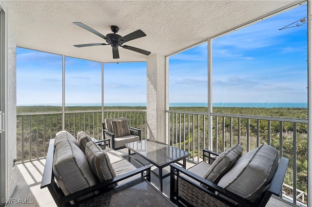 sunroom / solarium featuring ceiling fan, a water view, and a healthy amount of sunlight