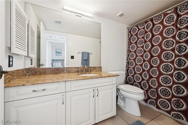 bathroom with tile patterned flooring, vanity, and toilet