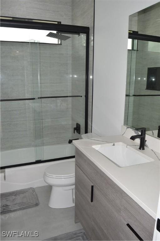 full bathroom with vanity, toilet, and bath / shower combo with glass door