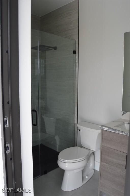 bathroom with walk in shower, vanity, and toilet