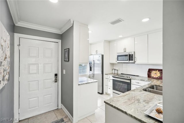 kitchen with light stone counters, stainless steel appliances, sink, light tile patterned floors, and white cabinets