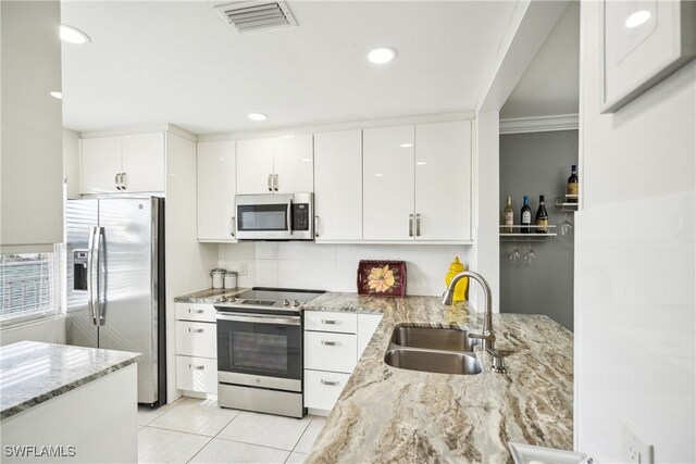 kitchen with white cabinetry, sink, stainless steel appliances, and light stone counters