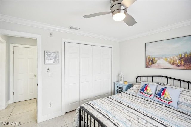 tiled bedroom with ceiling fan, a closet, and ornamental molding