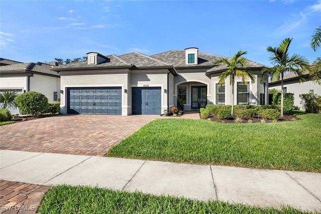 view of front of home featuring a garage, a front yard, and french doors