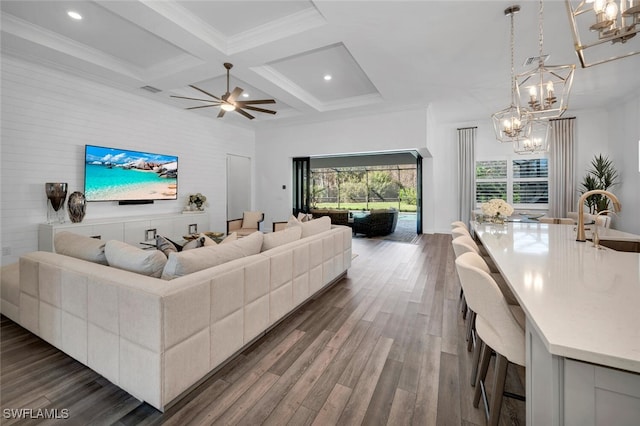 living room featuring ceiling fan, coffered ceiling, beamed ceiling, dark hardwood / wood-style floors, and crown molding