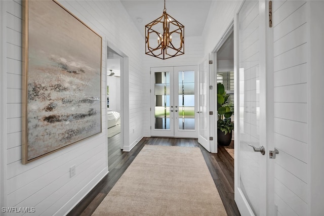 doorway to outside featuring french doors, dark wood-type flooring, and a notable chandelier