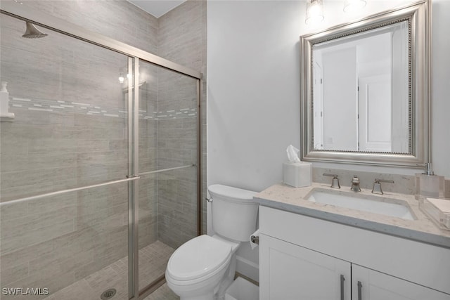 bathroom with toilet, vanity, and walk in shower