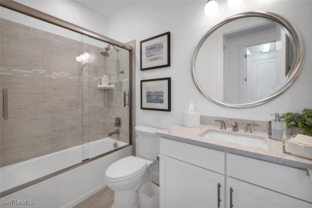 full bathroom featuring shower / bath combination with glass door, vanity, and toilet