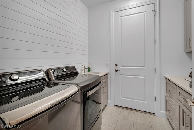 laundry room featuring washer and dryer, cabinets, and sink