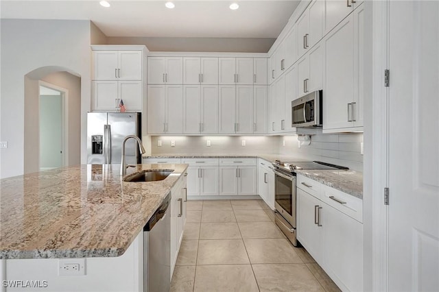 kitchen featuring a kitchen island with sink, white cabinetry, sink, and stainless steel appliances