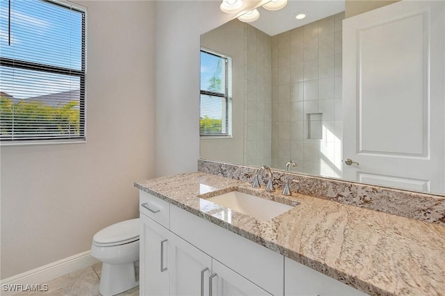 bathroom featuring tile patterned flooring, vanity, toilet, and walk in shower