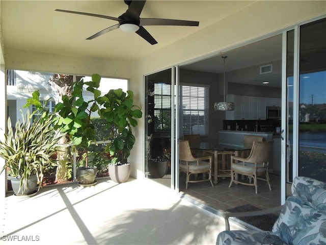 sunroom featuring ceiling fan