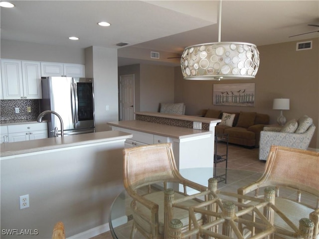 kitchen with white cabinetry, sink, tasteful backsplash, stainless steel fridge, and light tile patterned floors