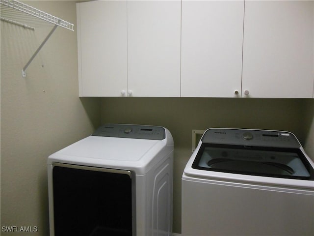 washroom featuring separate washer and dryer and cabinets