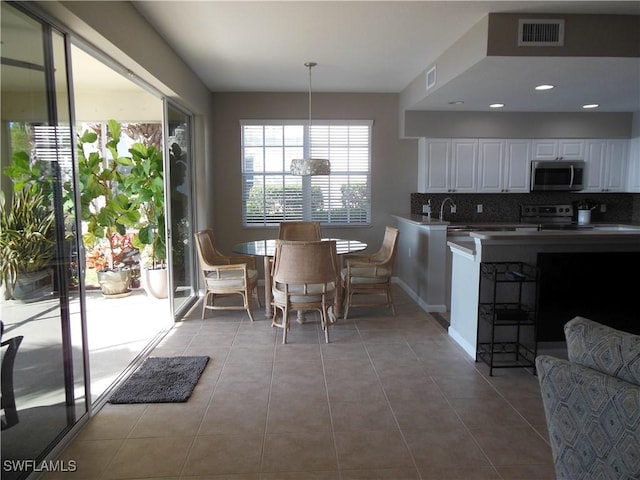 dining area featuring light tile patterned floors and an inviting chandelier