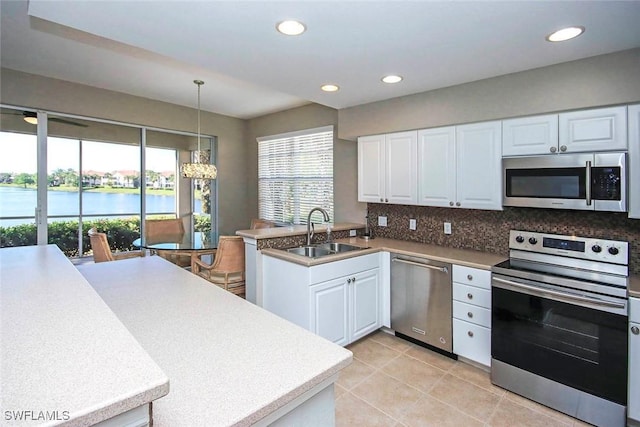 16590 Crownsbury Way Unit 102, Fort Myers, FL 33908 - kitchen with stainless steel appliances, a water view, backsplash, a sink, and white cabinets