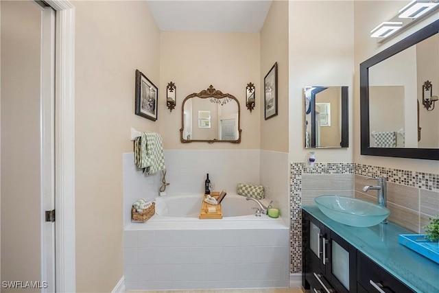 bathroom with vanity and tiled tub