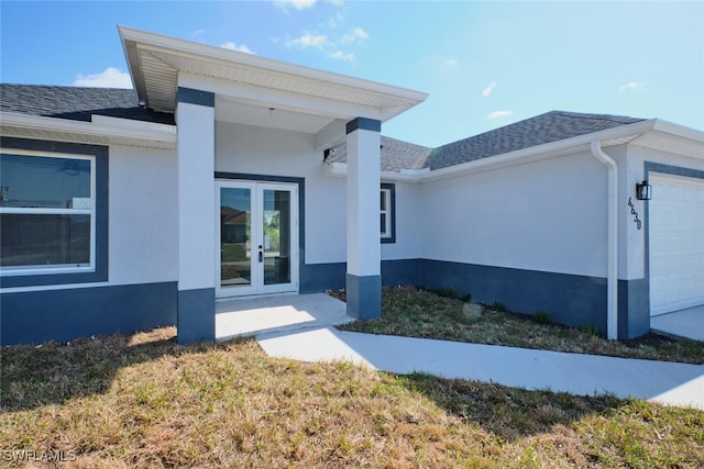 entrance to property featuring a garage and french doors