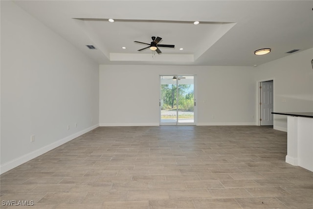 spare room with a tray ceiling and ceiling fan