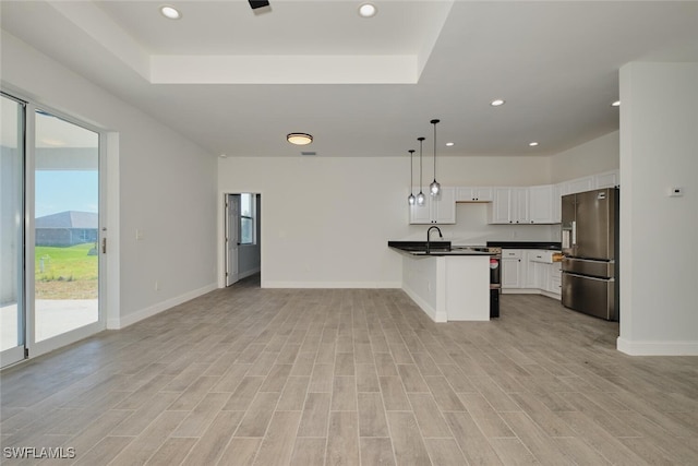 kitchen featuring a wealth of natural light, stainless steel fridge with ice dispenser, white cabinets, and pendant lighting