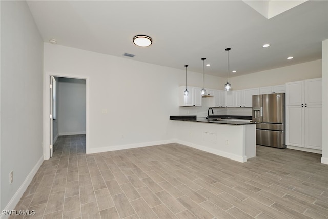 kitchen with white cabinetry, sink, light hardwood / wood-style flooring, stainless steel refrigerator with ice dispenser, and pendant lighting