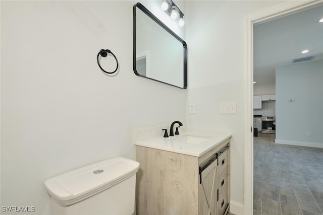 bathroom featuring hardwood / wood-style floors, vanity, and toilet