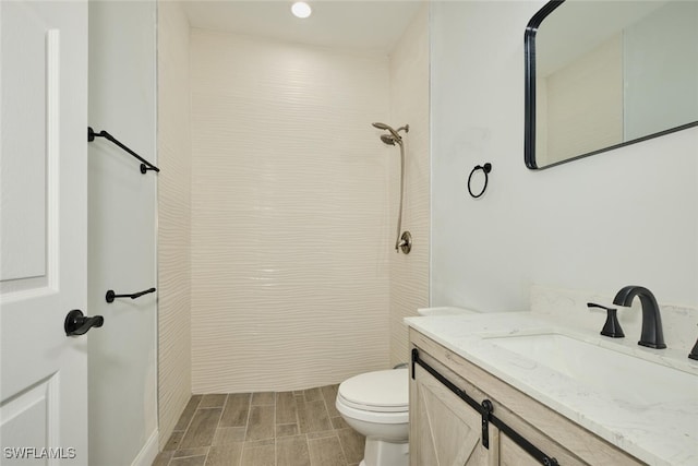 bathroom featuring a shower, vanity, and toilet