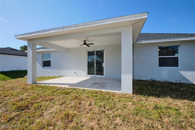 back of house featuring a lawn, ceiling fan, and a patio area