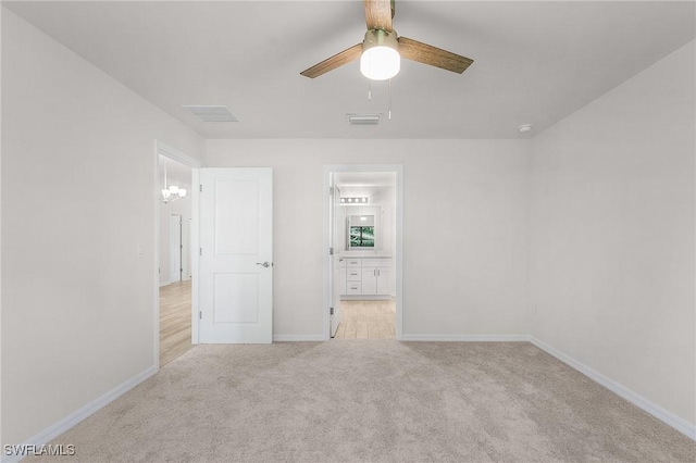 unfurnished bedroom featuring ceiling fan, light colored carpet, and ensuite bathroom