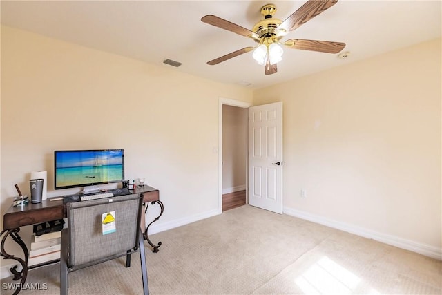 carpeted office space with ceiling fan