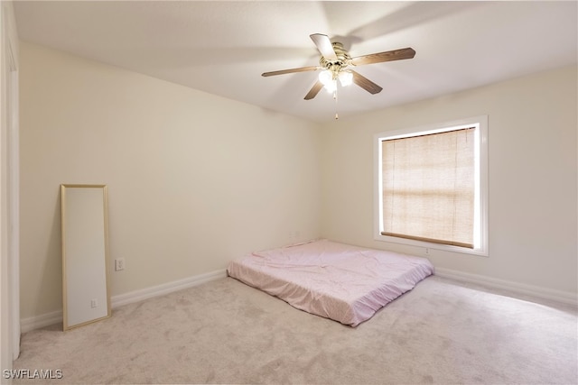 unfurnished bedroom with light carpet and ceiling fan