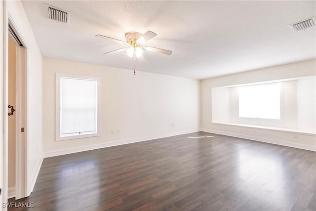 unfurnished room with dark wood-type flooring, a healthy amount of sunlight, and ceiling fan