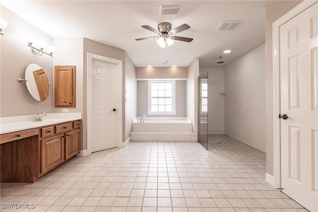 bathroom featuring ceiling fan, vanity, tile patterned flooring, and plus walk in shower