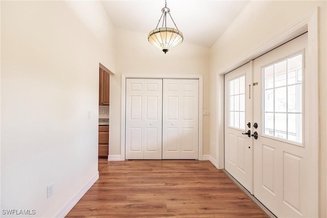 doorway to outside with vaulted ceiling, hardwood / wood-style flooring, and french doors