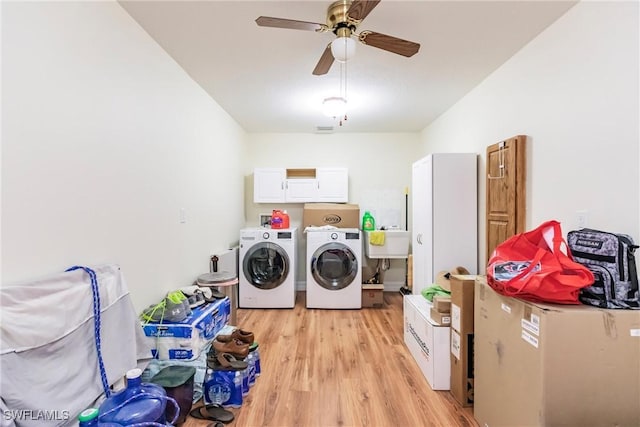 laundry area with washer and clothes dryer, ceiling fan, light wood-type flooring, cabinets, and sink