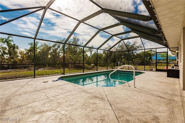 view of swimming pool featuring a lanai and a patio area