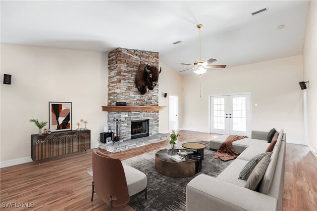 living room featuring french doors, lofted ceiling, ceiling fan, a fireplace, and hardwood / wood-style floors