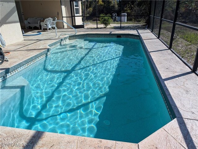 view of swimming pool with a lanai and a patio area