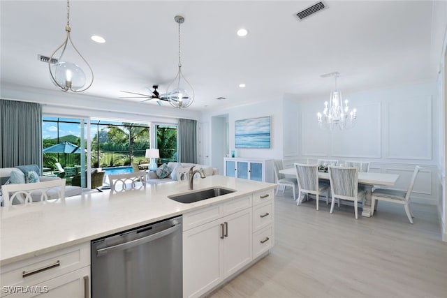 kitchen featuring stainless steel dishwasher, ceiling fan, sink, white cabinets, and hanging light fixtures