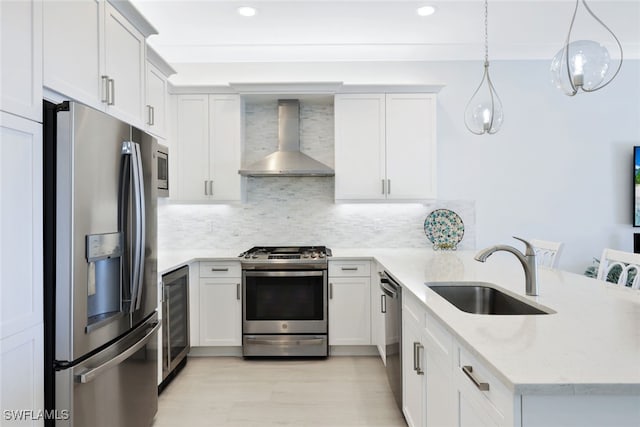 kitchen featuring pendant lighting, sink, wall chimney exhaust hood, decorative backsplash, and appliances with stainless steel finishes