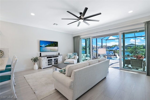 living room with ceiling fan, light hardwood / wood-style floors, and ornamental molding