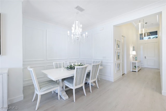 dining area with light hardwood / wood-style floors and ornamental molding