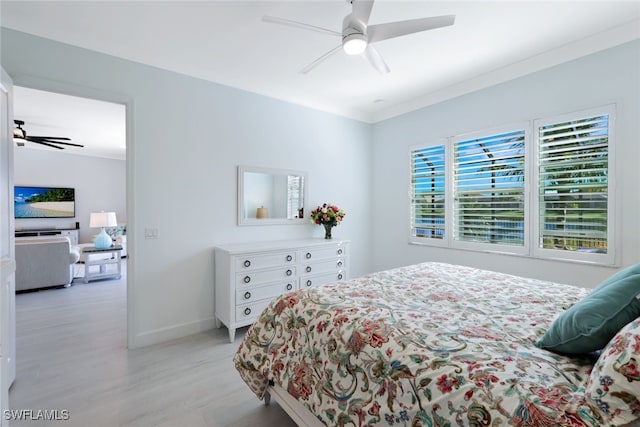 bedroom featuring ceiling fan, light wood-type flooring, and crown molding