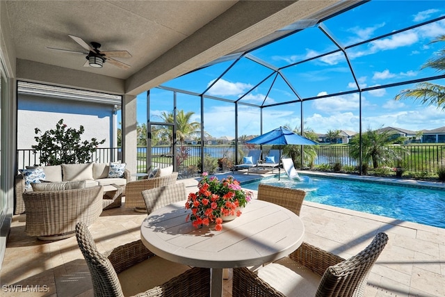 view of pool with an outdoor living space, pool water feature, ceiling fan, a water view, and a patio